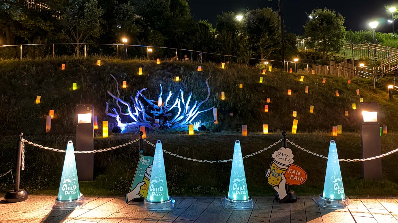 キャンドルアートと光るPOPコーンが、流木アートを囲んで夜の狭山市駅西口公園内を照している。