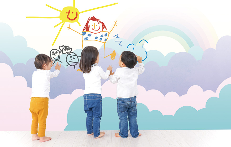 三人の子供が壁に絵を描いている写真。